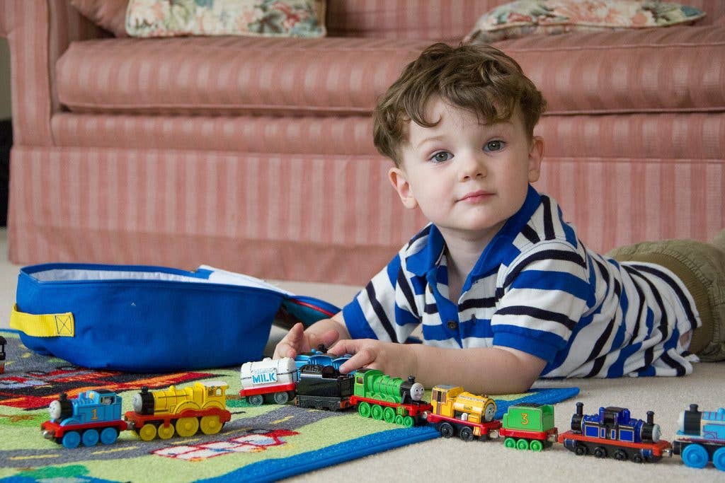 Toddler boy playing with thomas model train