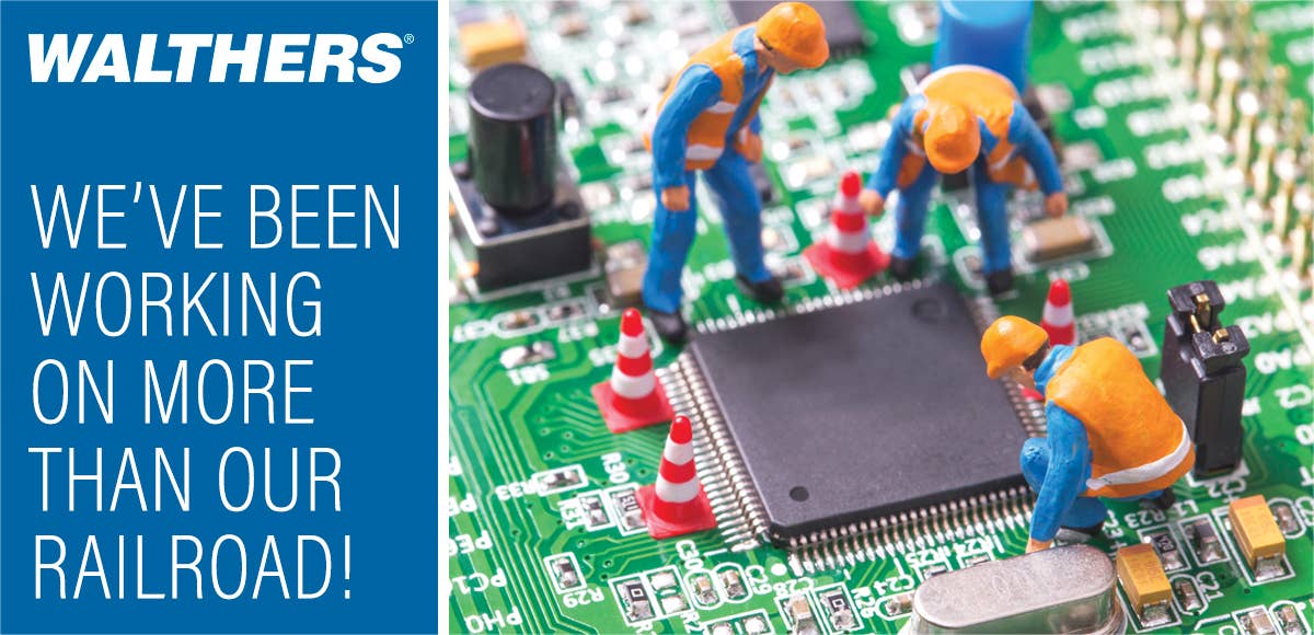 We've been working on more than our railroad! Photo of scale construction figures working on a computer motherboard.